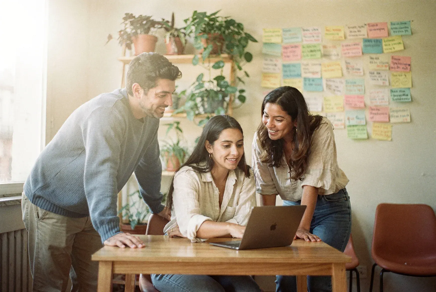 Equipo trabajando junto en la estrategia de un cliente frente a un tablero de ideas